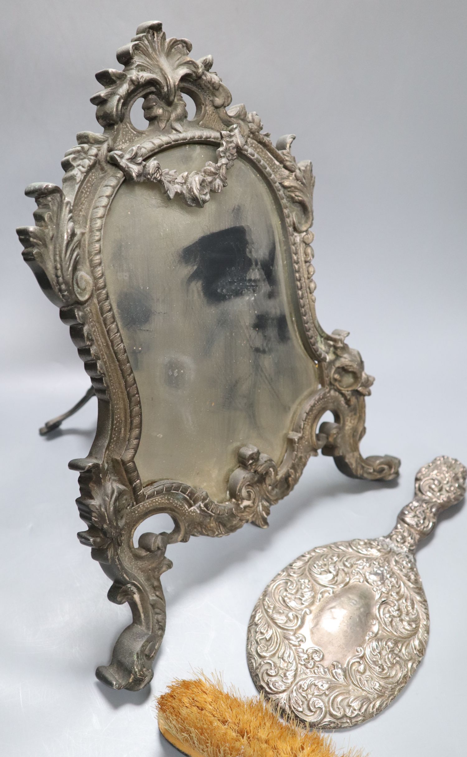 A Victorian cast metal easel mirror and a white metal mounted brush set